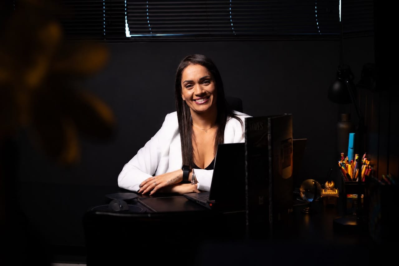 Sabrina Sorriso trabalhando em uma mesa com plantas e materiais de arquitetura